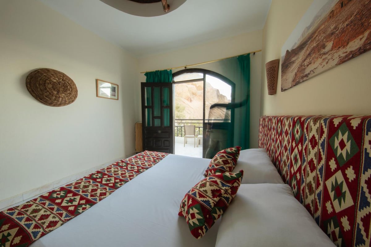 The Bedouin Moon Hotel Dahab bedroom with two beds and a patterned headboard.
