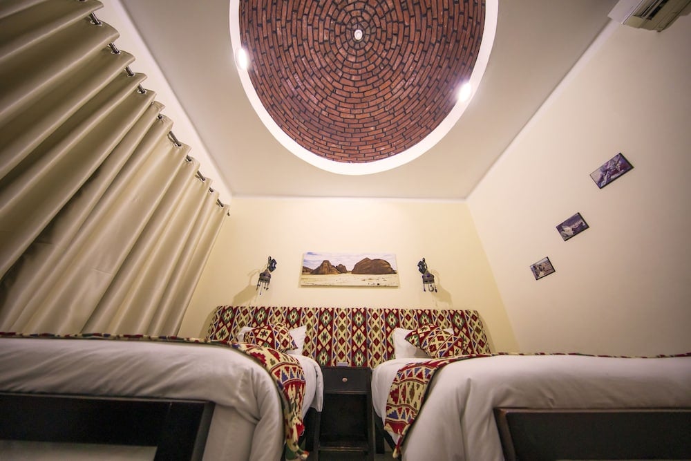 The Bedouin Moon Hotel Dahab twin bedroom with patterned headboards and a circular brick ceiling.