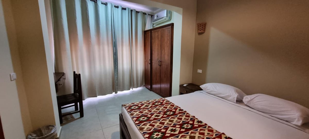 The Bedouin Moon Hotel Dahab bedroom with a double bed and patterned bed runner.