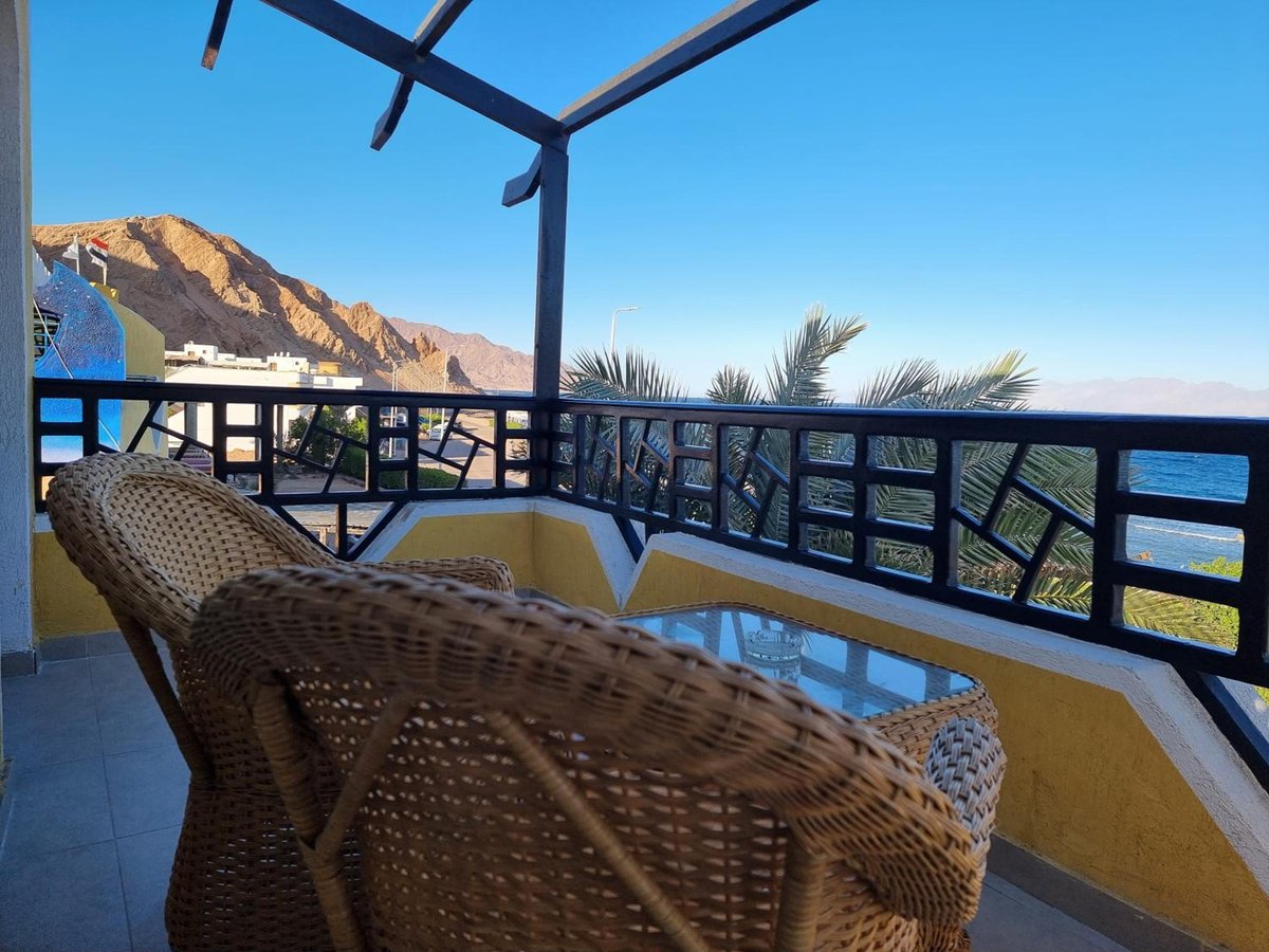 The Bedouin Moon Hotel Dahab terrace with wicker seating and a sea view.