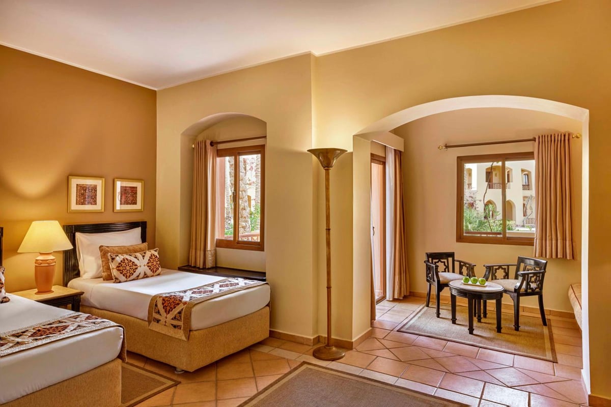 Steigenberger Coraya Beach (Adults Friendly 16+) guest room with twin beds and a dining area.