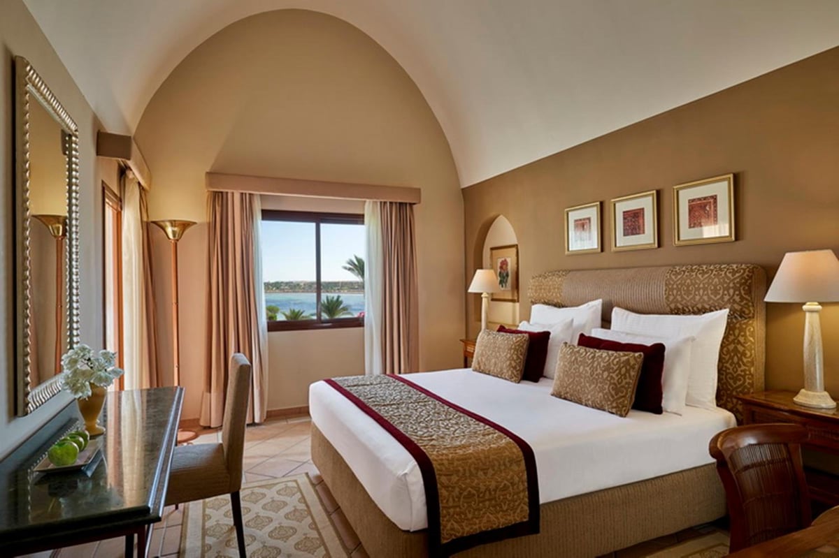 Steigenberger Coraya Beach (Adults Friendly 16+) bedroom with an arched ceiling and sea-view window.
