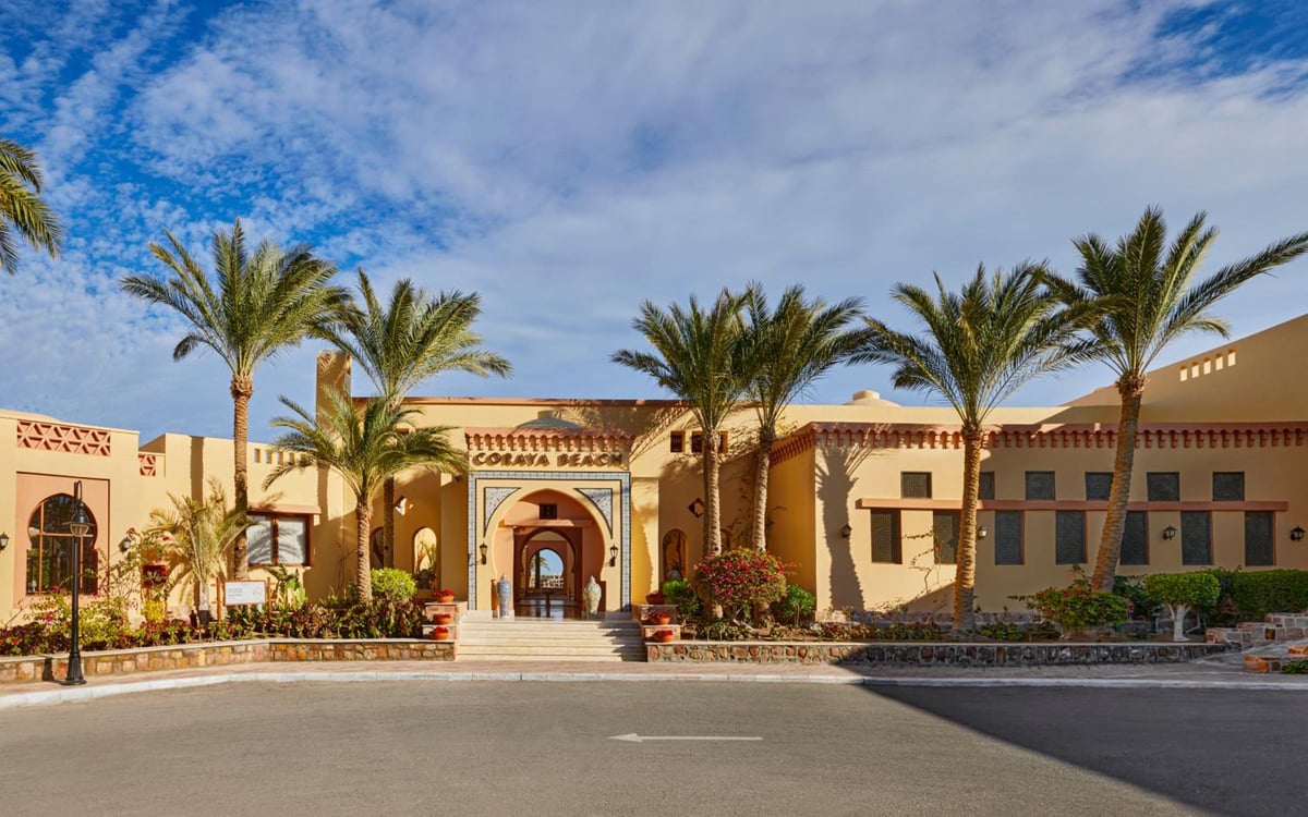 Steigenberger Coraya Beach entrance with an arched doorway and palm trees.