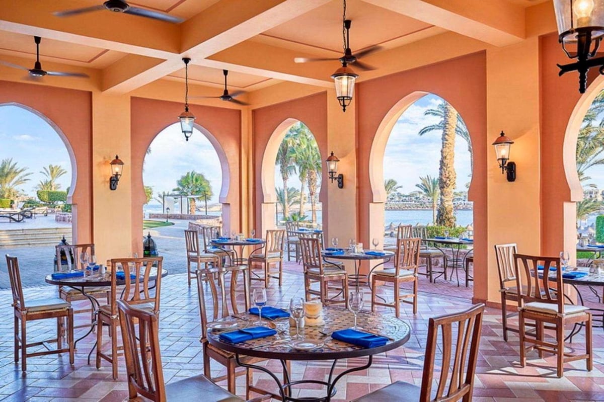 Steigenberger Coraya Beach (Adults Friendly 16+) restaurant terrace with arched openings and dining tables.