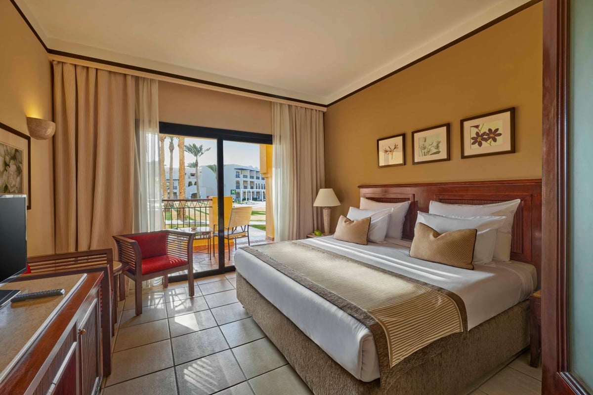 JAZ Lamaya Resort guest room with a large bed and balcony access.