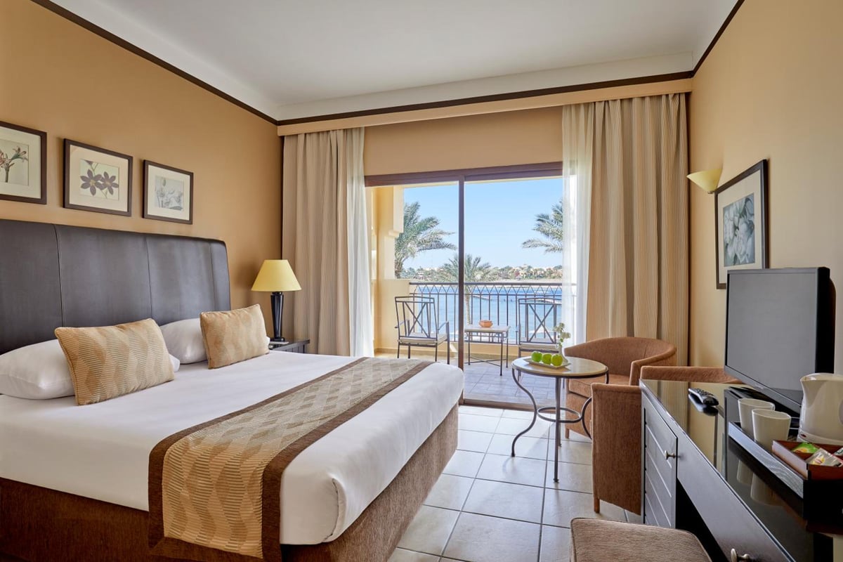 JAZ Lamaya Resort guest room with a bed and balcony.