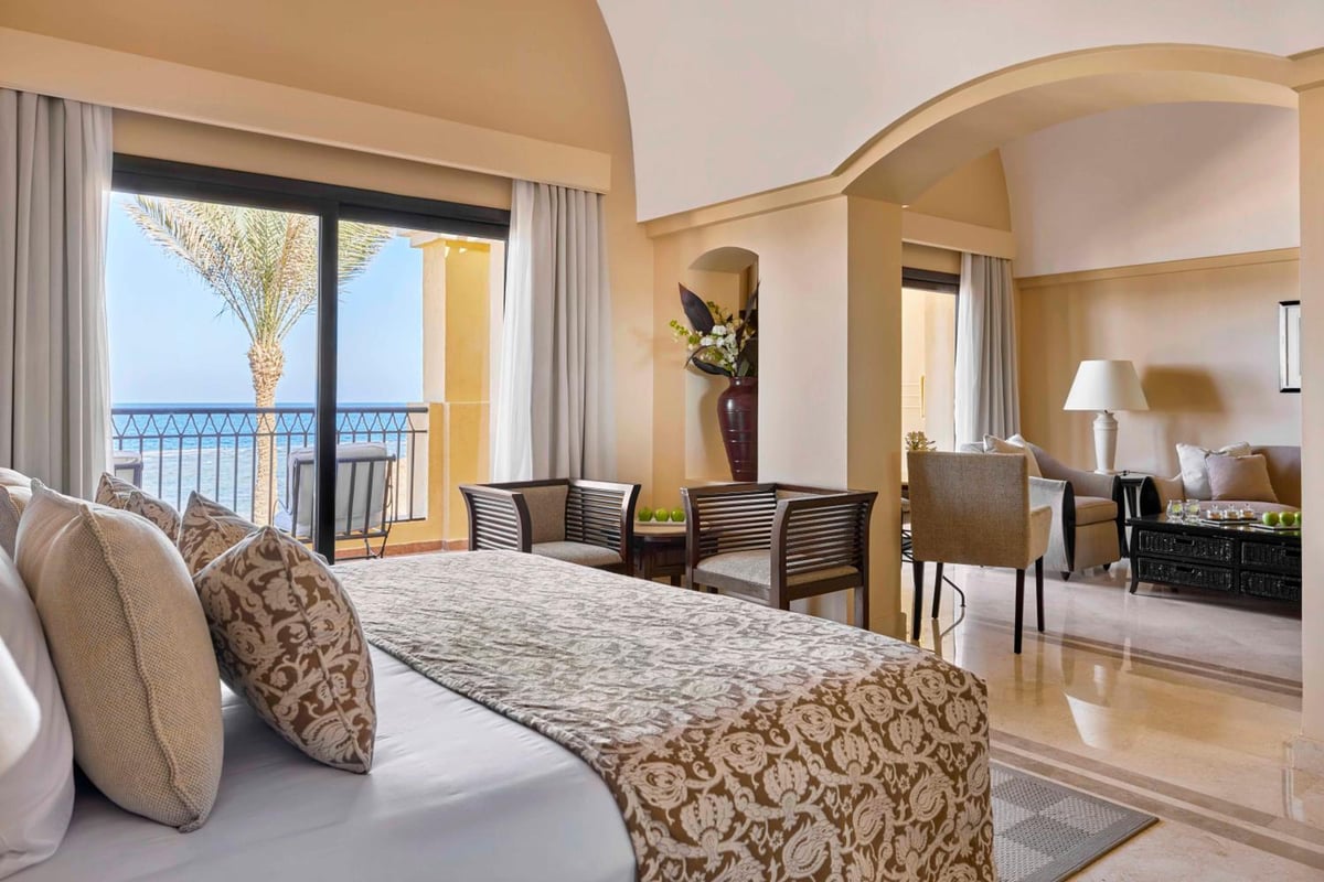 JAZ Lamaya Resort bedroom with a balcony and an arched opening to the sitting area.