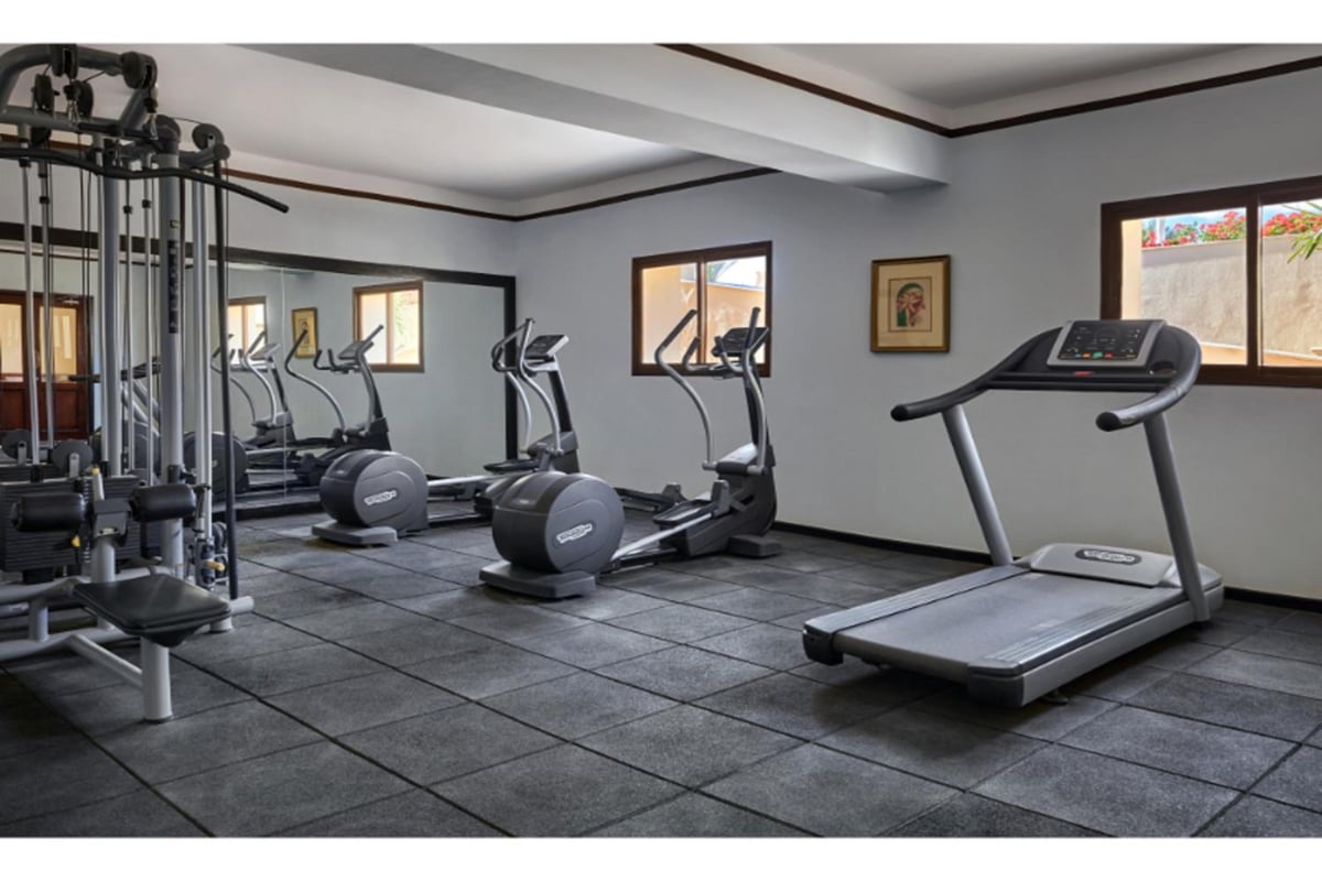 JAZ Lamaya Resort gym with a treadmill and mirrored wall.