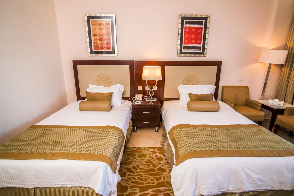 Tolip Hotel Alexandria twin room with two beds and patterned bedspreads.