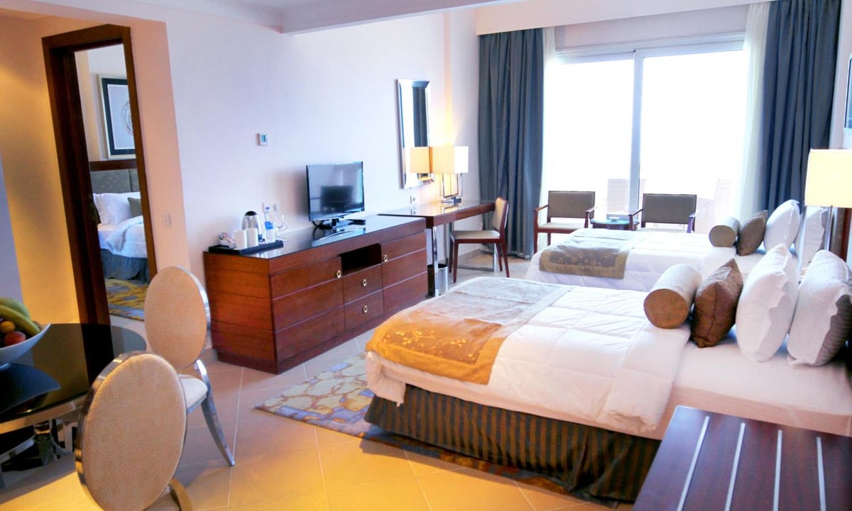 Tolip Hotel Alexandria guest room with two beds and large windows.