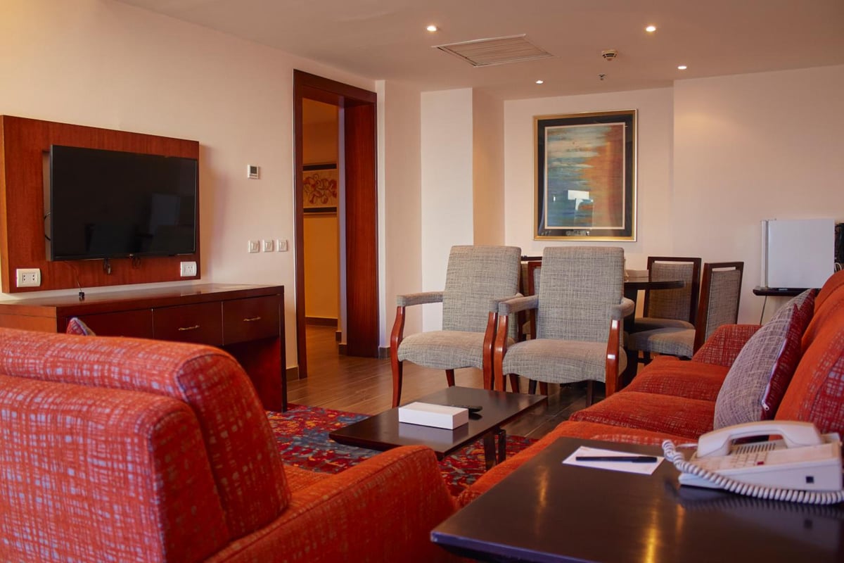 Tolip Hotel Alexandria sitting area with patterned sofas and a wall-mounted television.