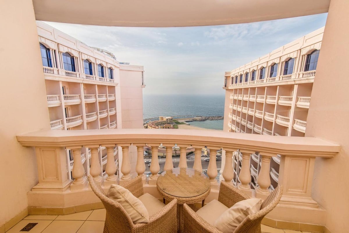 Tolip Hotel Alexandria balcony with wicker seating and a sea view.