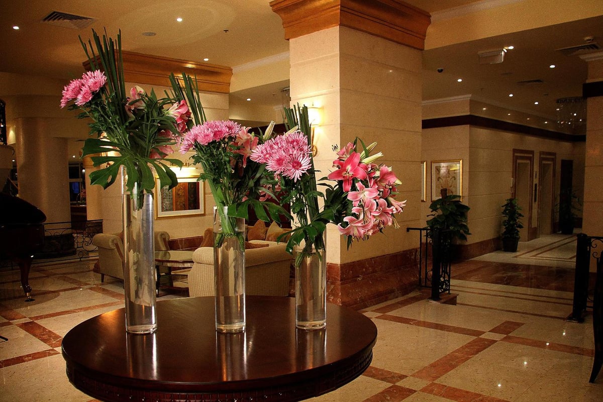 Tolip Hotel Alexandria lobby with flower arrangements and square columns.