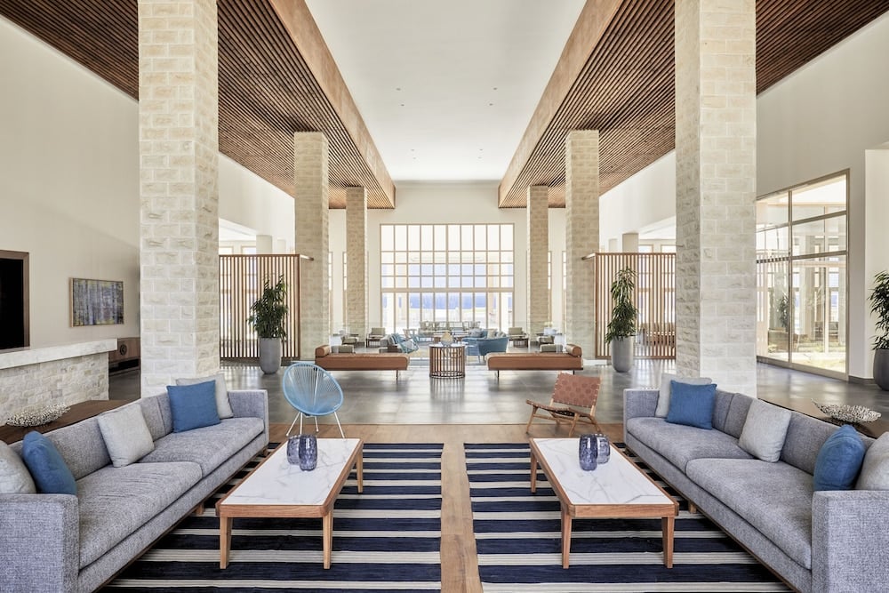 JAZ Elite Maraya lobby lounge with stone columns and tall windows.