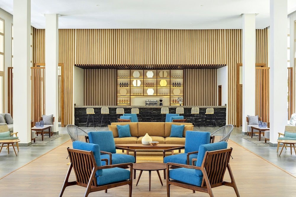 JAZ Elite Maraya lobby lounge with blue seating and a backlit bar.