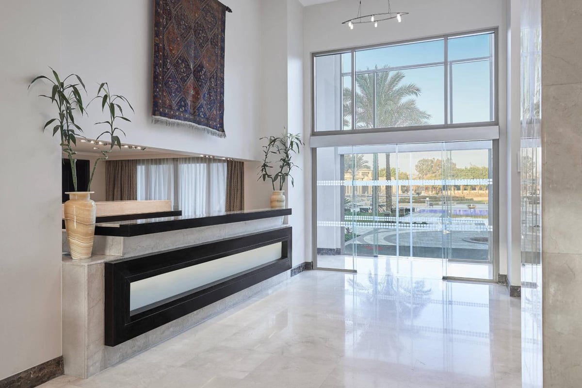 Marriott Mena House Cairo lobby with stone reception desk and floor-to-ceiling glass entrance.