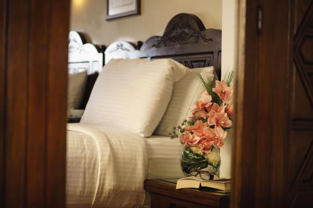 Movenpick Resort Sharm El Sheikh bedroom with a white bed and pink flowers.