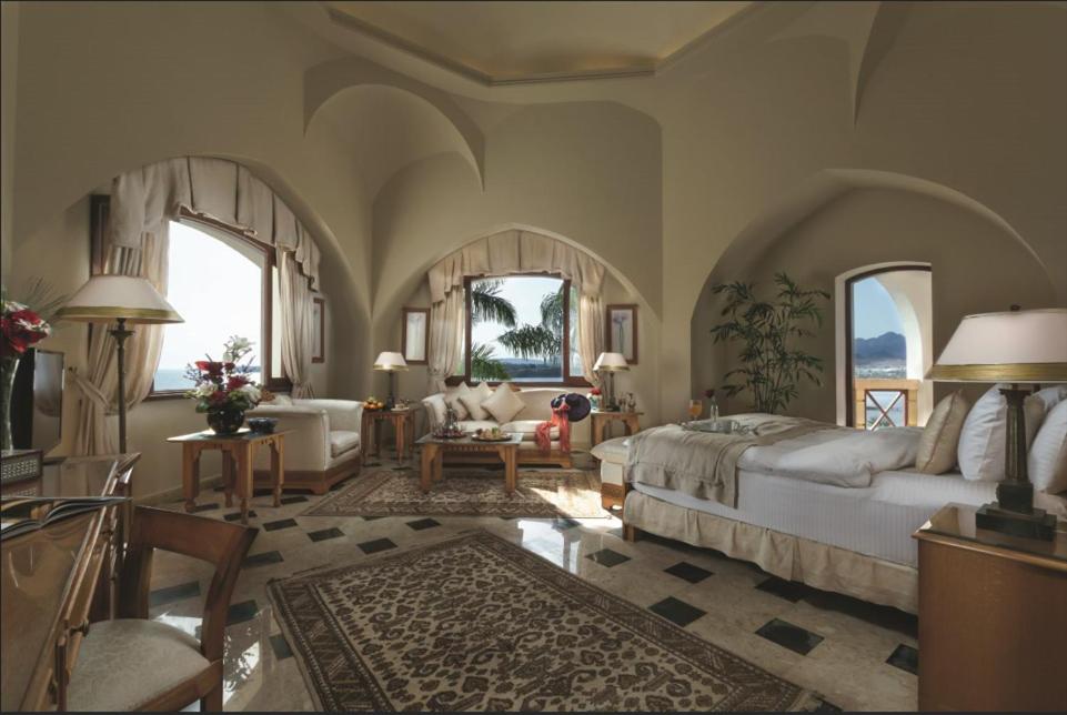 Movenpick Resort Sharm El Sheikh suite with a sitting area and arched windows.