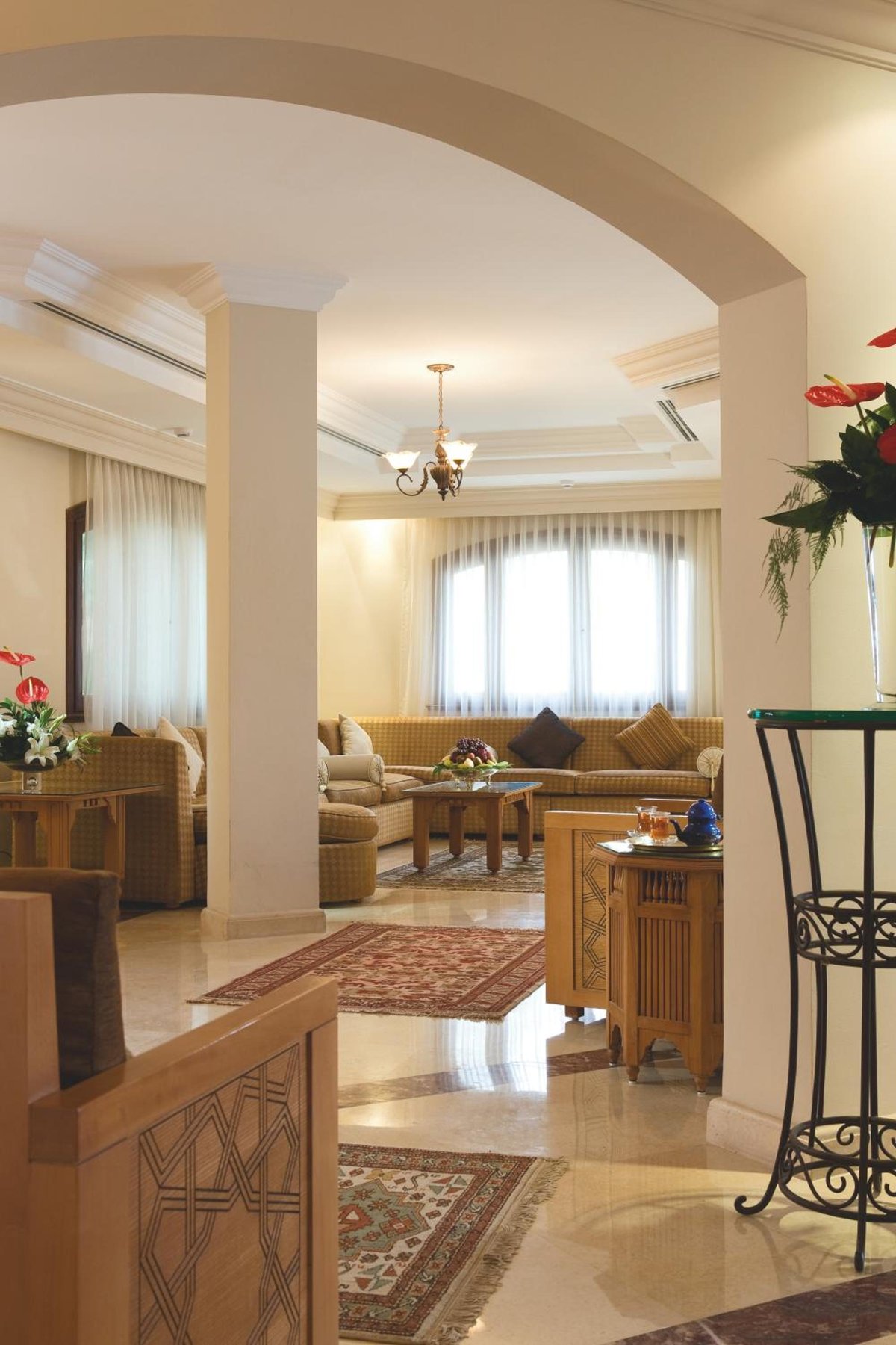 Movenpick Resort Sharm El Sheikh living room with an arched opening and sofas.