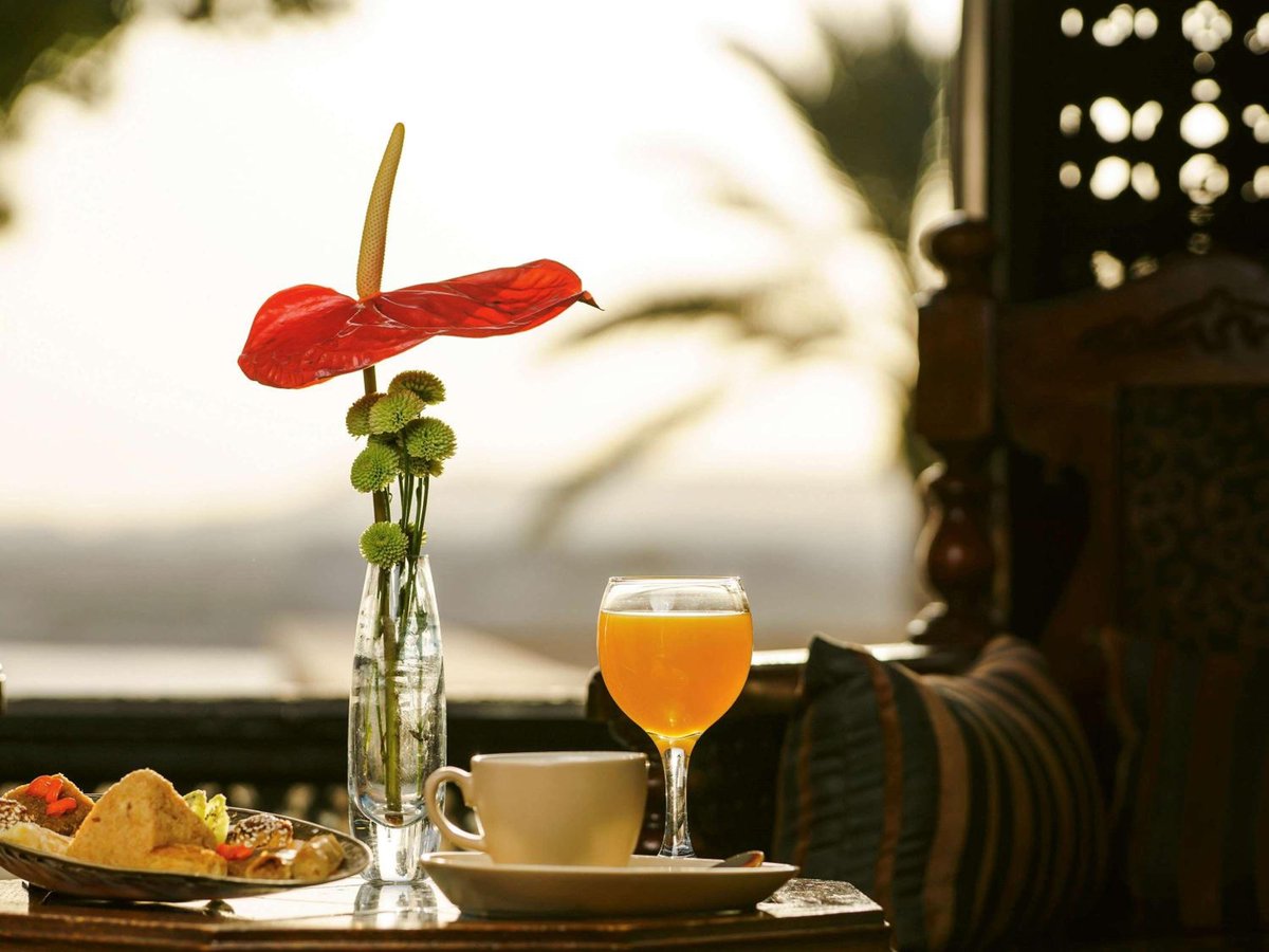 Movenpick Resort Sharm El Sheikh dining terrace with a red flower and water beyond.