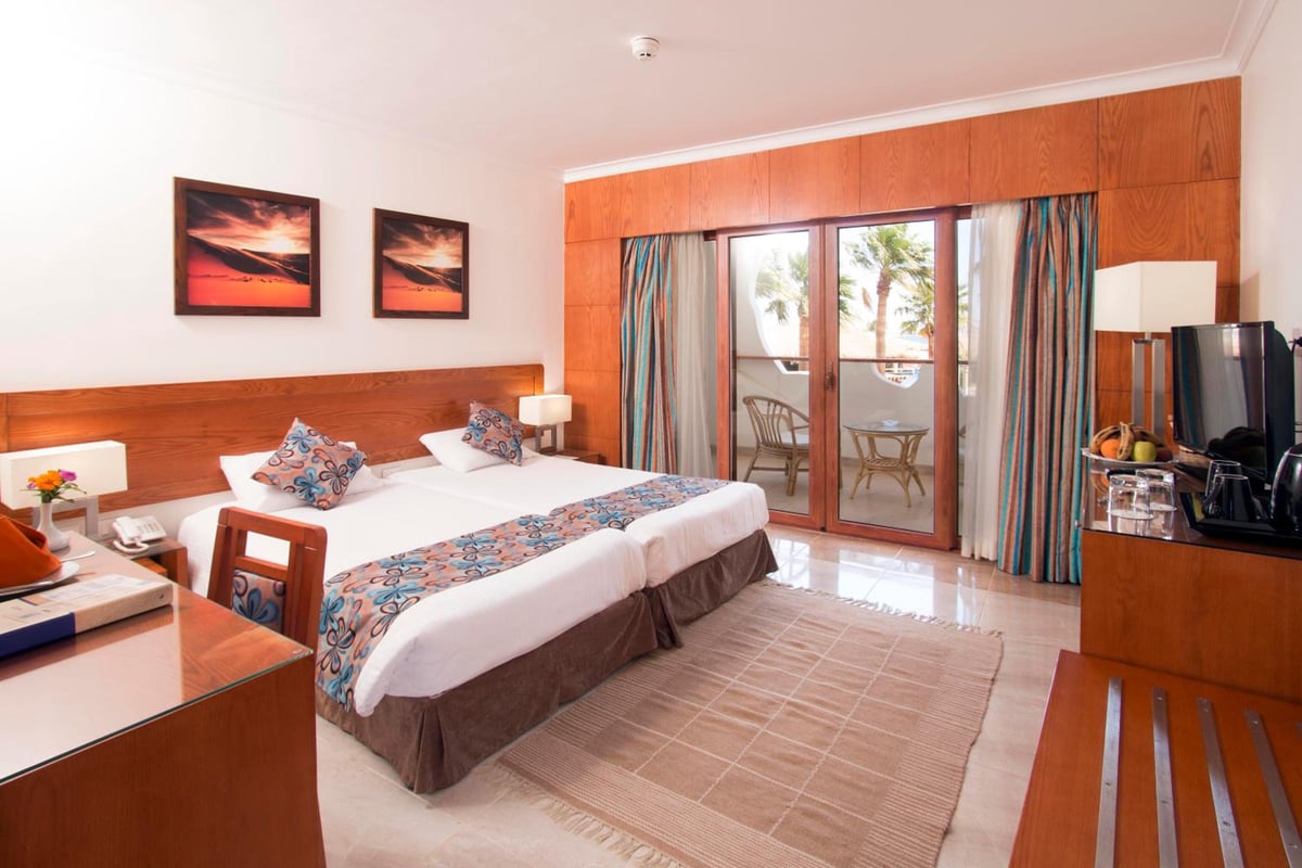 Swiss Inn Resort Dahab guest room with a double bed and sliding glass doors.