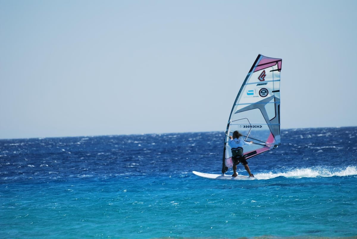 Swiss Inn Resort Dahab sea with a windsurfer and turquoise water.