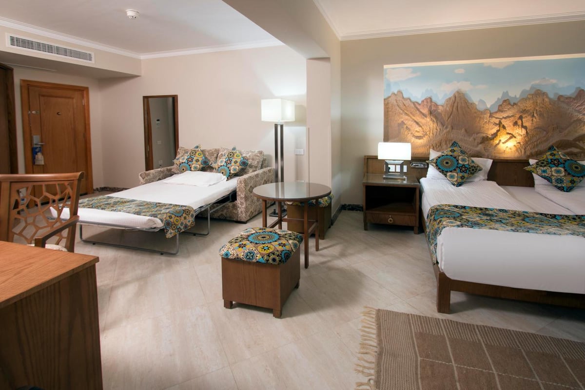 Swiss Inn Resort Dahab guest room with two beds and a mountain mural.