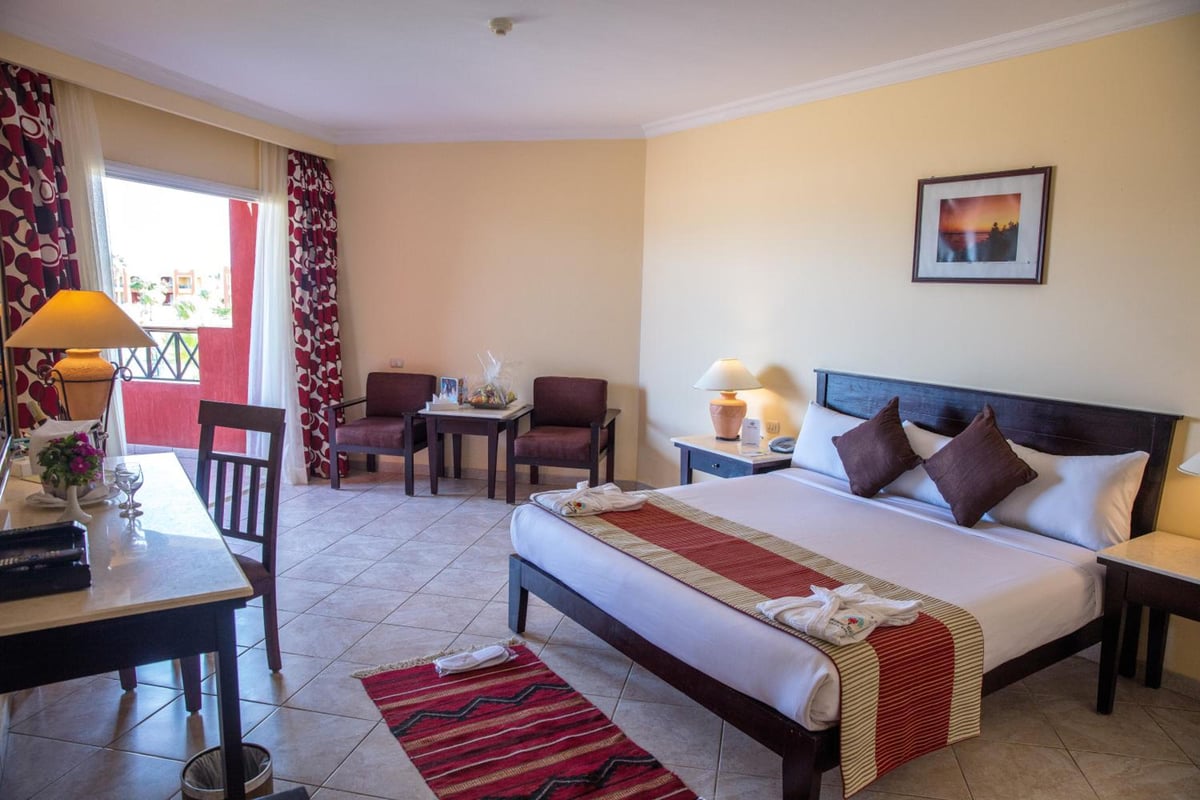 Casa Mare Resort Marsa Alam guest room with a large bed and a seating area.