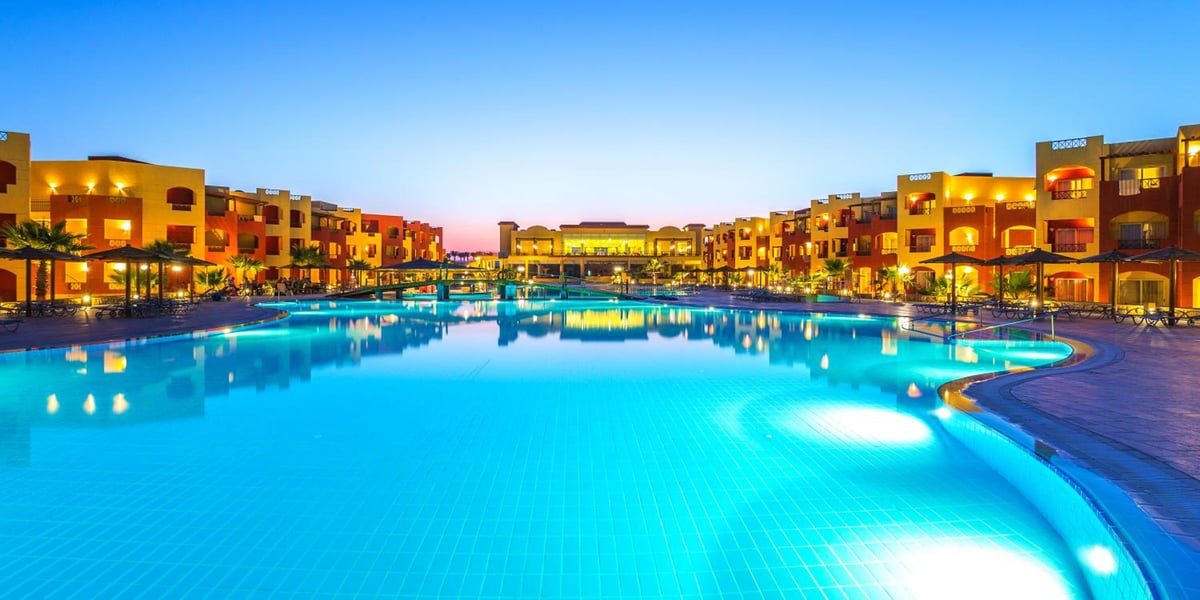 Casa Mare Resort Marsa Alam pool with illuminated water and surrounding buildings.