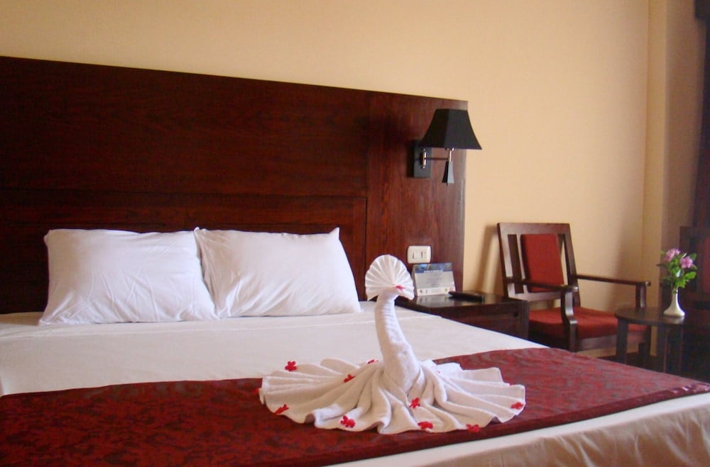 Brayka Bay Resort guest room with a red bedspread and dark wood headboard.