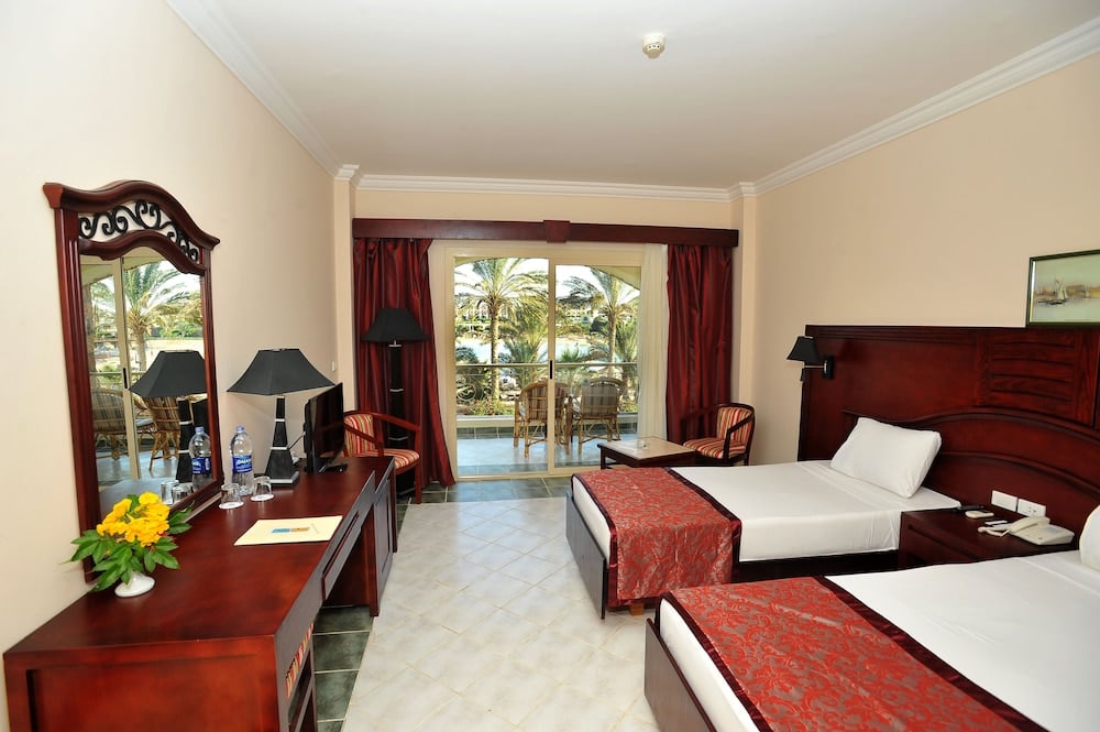 Brayka Bay Resort guest room with twin beds and balcony doors.