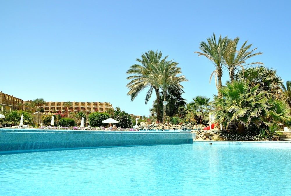Brayka Bay Resort pool with palm trees and resort buildings.