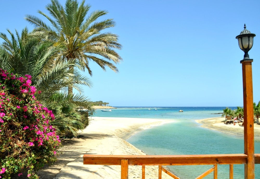 Brayka Bay Resort beach with a turquoise lagoon and palm trees.