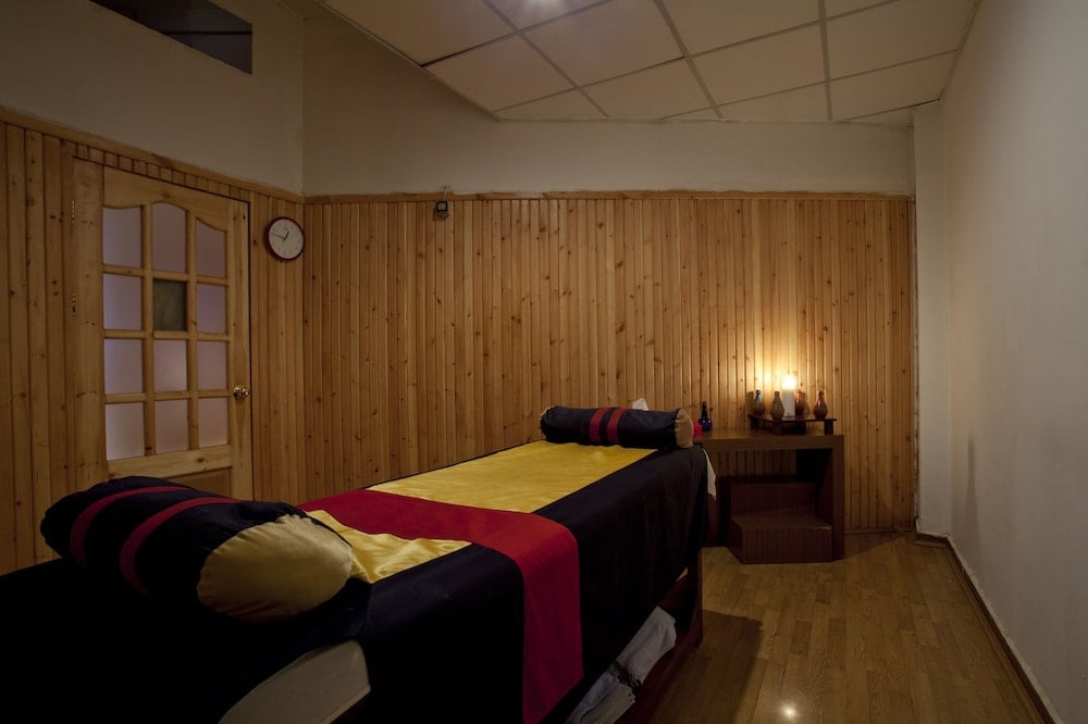 Brayka Bay Resort massage room with two massage tables and wood-paneled walls.
