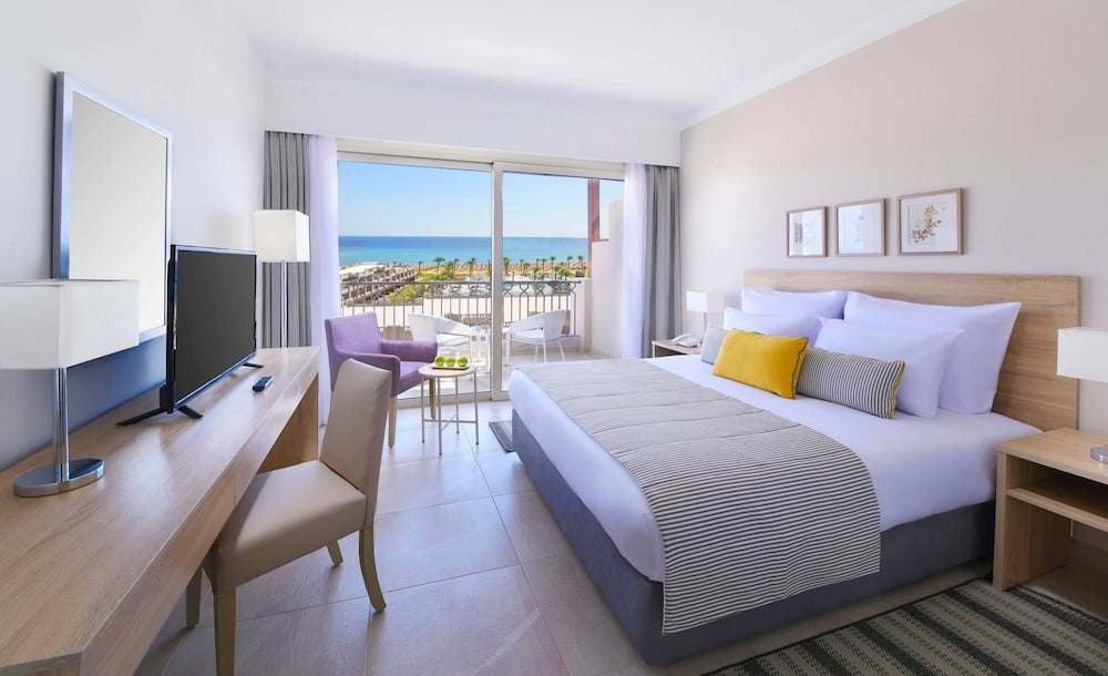 JAZ Costa Mares guest room with a large bed and a balcony overlooking the sea.