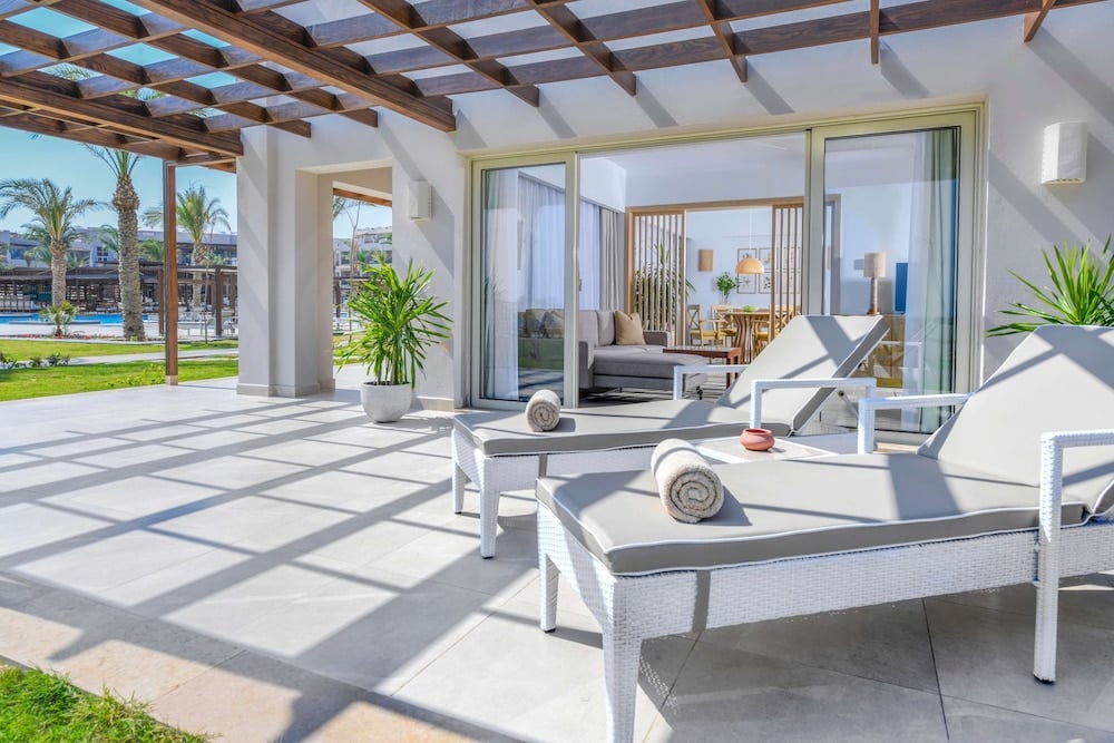 JAZ Costa Mares covered terrace with white loungers and a timber pergola.