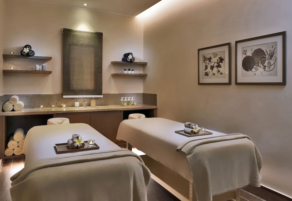 JAZ Costa Mares spa treatment room with two massage beds and framed artwork.