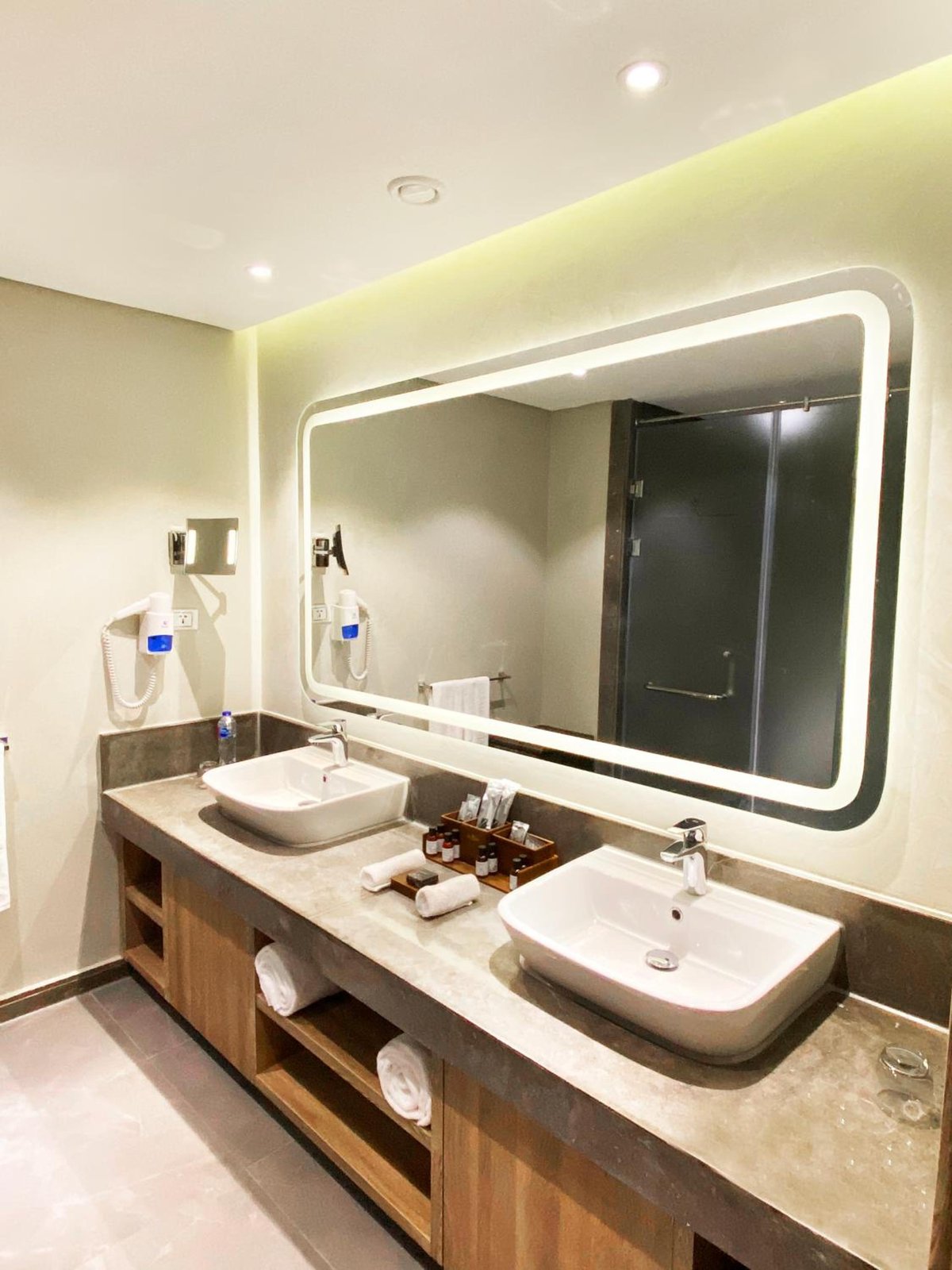 Rixos Premium Magawish Suites & Villas bathroom with double sinks and an illuminated mirror.