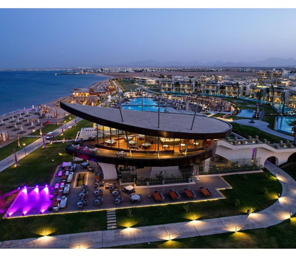 Rixos Premium Magawish Suites & Villas pavilion with a curved roof and glass walls.