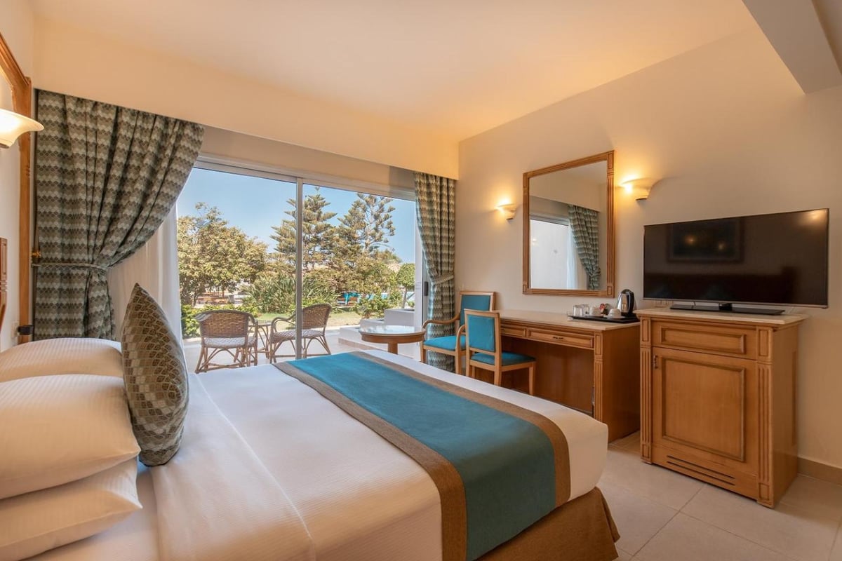 Long Beach Resort Hurghada guest room with a balcony and television.