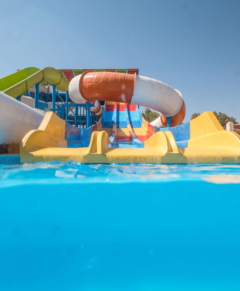 Long Beach Resort Hurghada waterpark pool with multicoloured slide lanes and a white and orange enclosed tube.