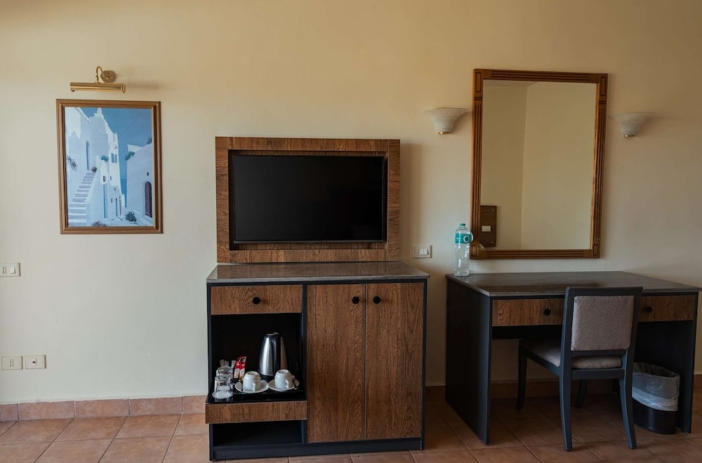 Long Beach Resort Hurghada guest room tv area with wall-mounted television and writing desk.