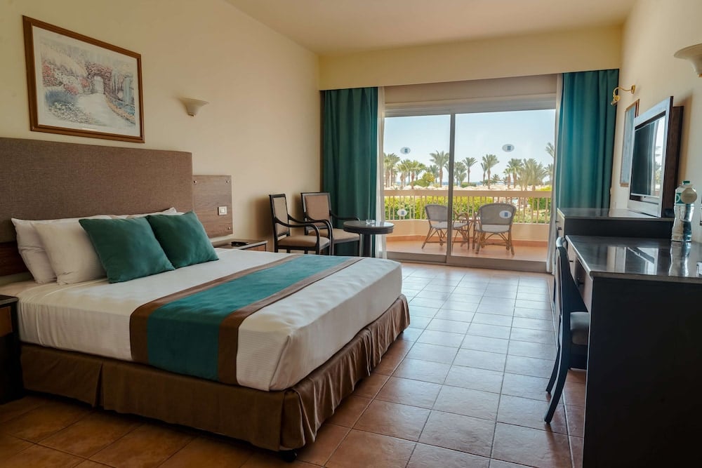 Long Beach Resort Hurghada guest room with bed and sliding patio doors.