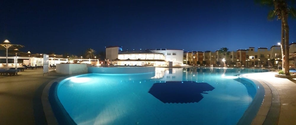 Blue Reef Marsa Alam outdoor pool with curved edges and illuminated water.