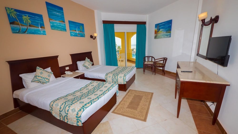 Blue Reef Marsa Alam twin bedroom with two beds and balcony doors.