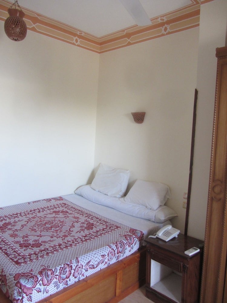 El Mesala Hotel Luxor bedroom with a patterned bed and painted ceiling trim.