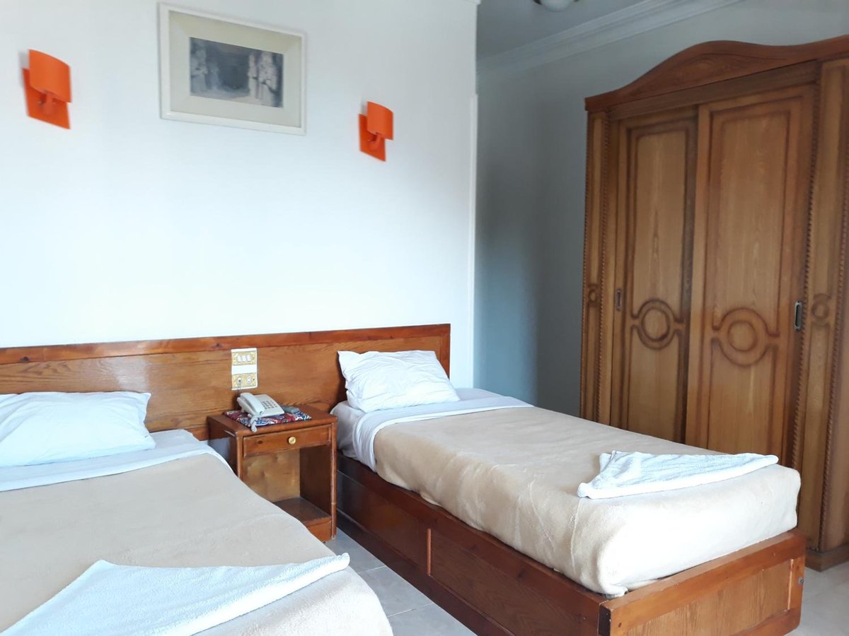 El Mesala Hotel Luxor twin bedroom with two single beds and a wooden wardrobe.