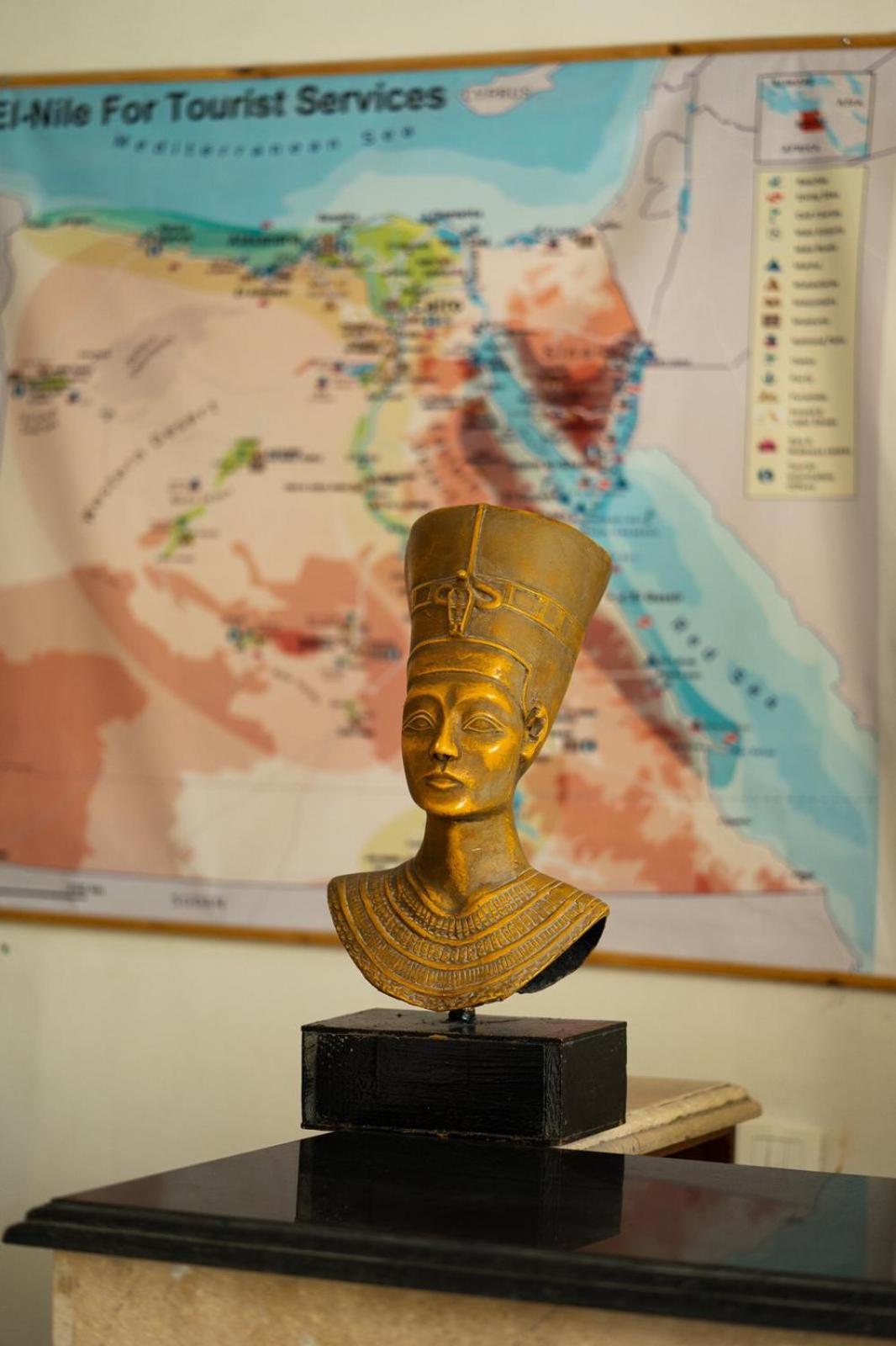El Mesala Hotel Luxor display area with a bust and a wall map.