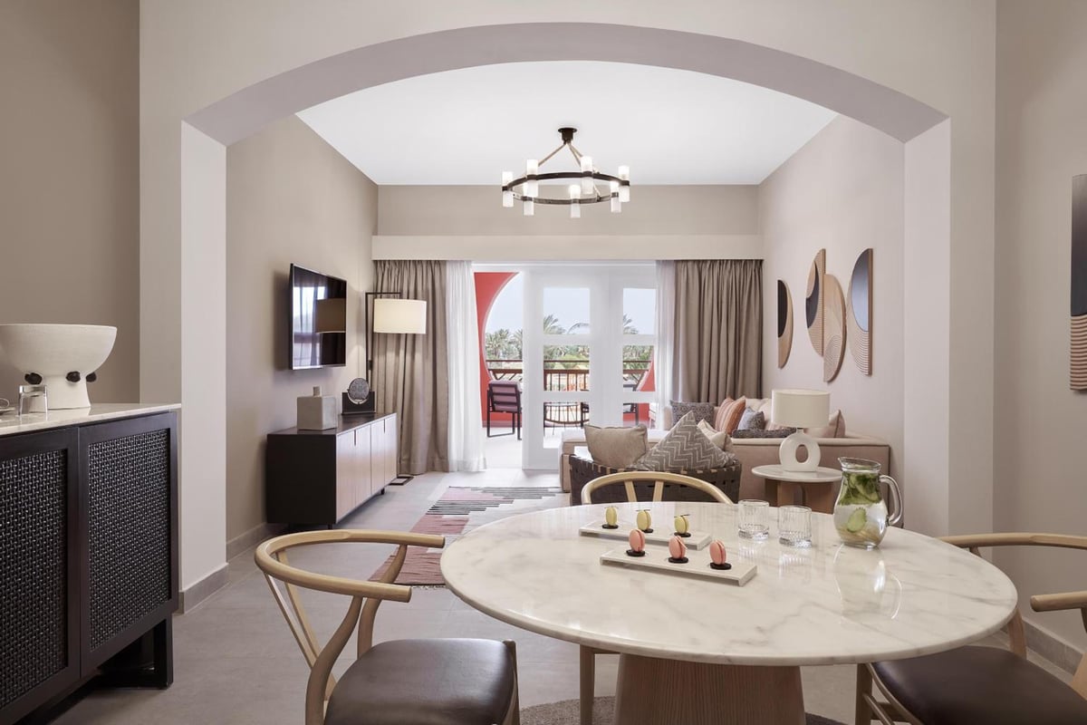 Steigenberger Golf Resort El Gouna living and dining area with a marble table and balcony doors.