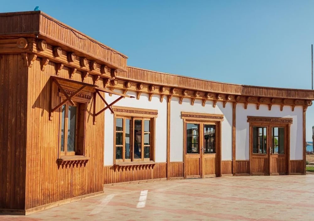 Laguna Beach Marsa Resort building facade with wooden cladding and white walls.